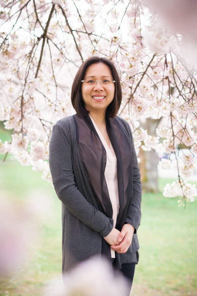 Lady standing under cherry blossoms