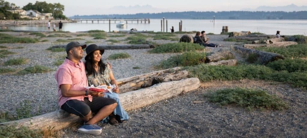 People sitting on log at the beach.