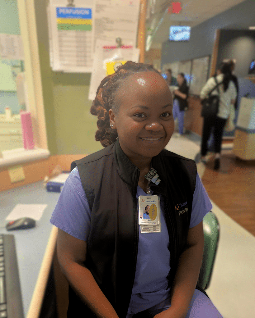 Critical care registered nurse sitting at desk smiling.