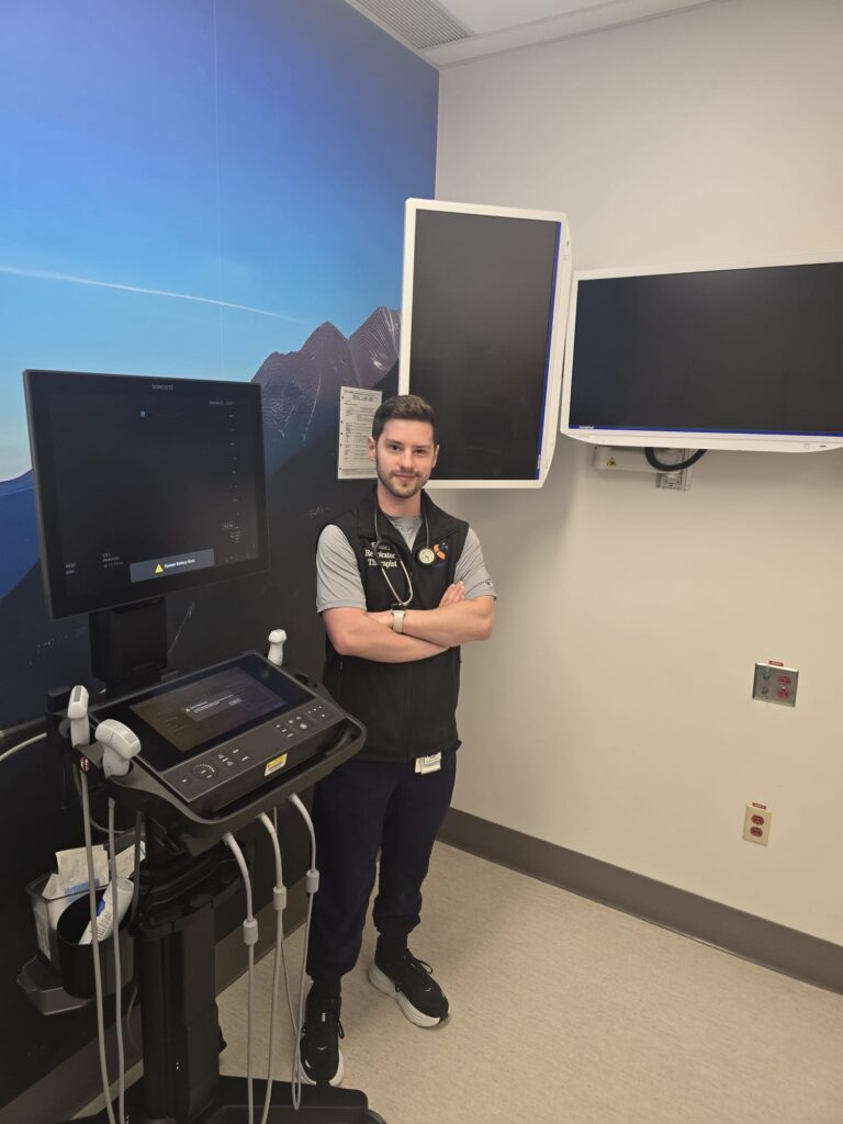 Fraser Health respiratory therapist standing in front of patient monitoring and diagnostic display